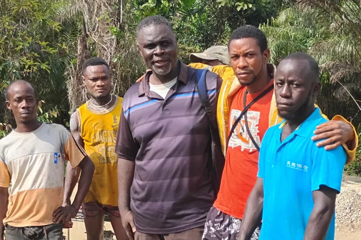 Project representative standing with local field workers in River Cess